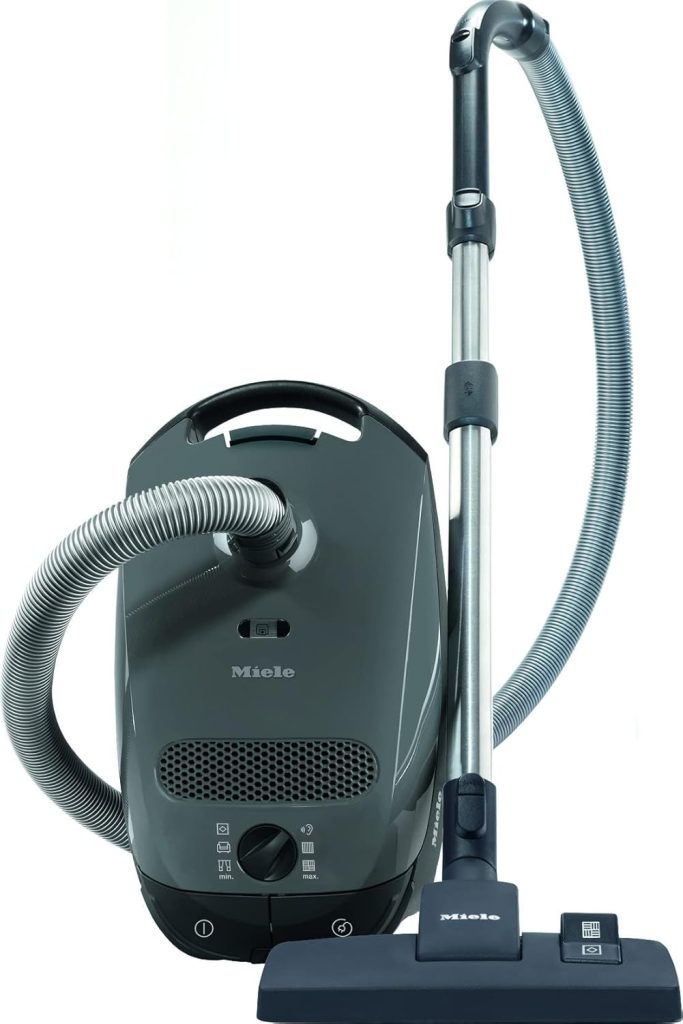 Miele Classic C1 Pure Suction PowerLine vacuum cleaner with a sleek canister design, lightweight build, and adjustable suction settings, equipped with a floorhead ideal for hard floors and low-pile carpets, displayed in a clean, modern home environment.






