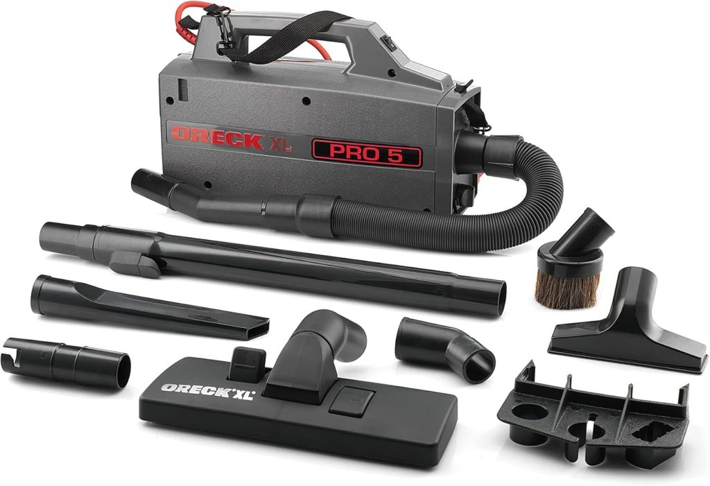 Oreck Commercial XL Pro 5 Canister Vacuum with a compact, lightweight design, featuring a shoulder strap for portability, long power cord, and versatile attachments, displayed in a professional or home setting for efficient cleaning of carpets, furniture, and tight spaces.







